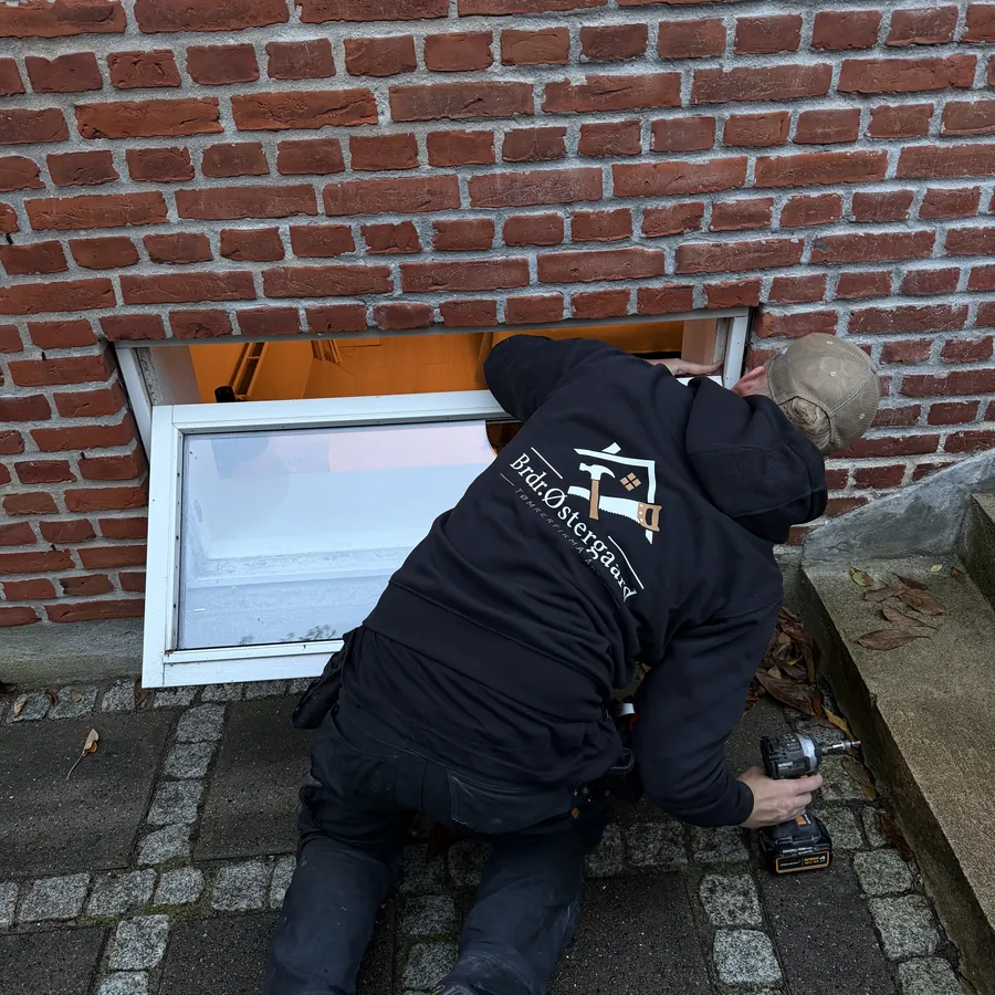 Victor holder vinduesrammen på plads i åbningen