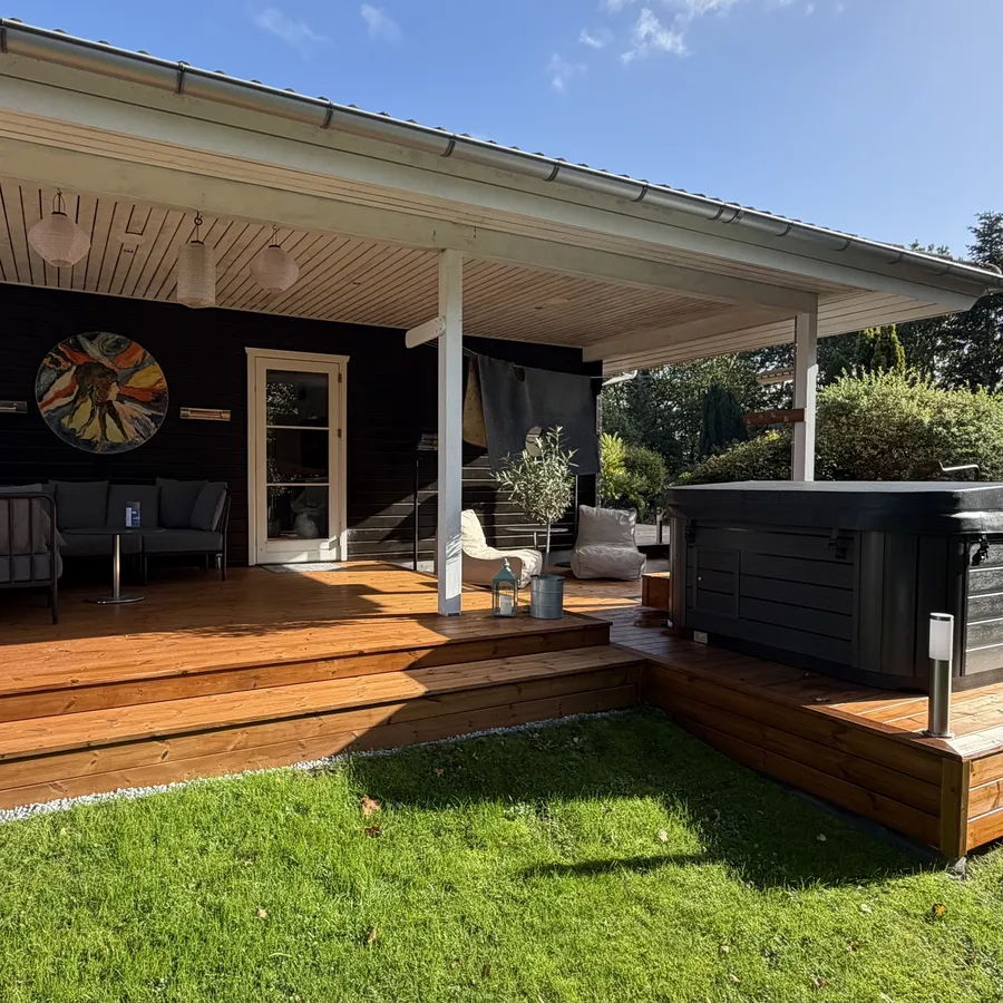 Efter: overdækket terrasse med sofa under taget og spa på dækket ved siden af
